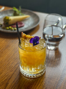 Passionfruit Bramble cocktail paired with Indian vegetarian tasting menu first course