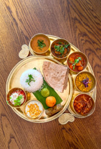 Indian Thali with different curries, sides, starters and dessert